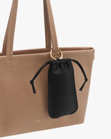 A tote bag with a drawstring pouch attached to one of its handles.