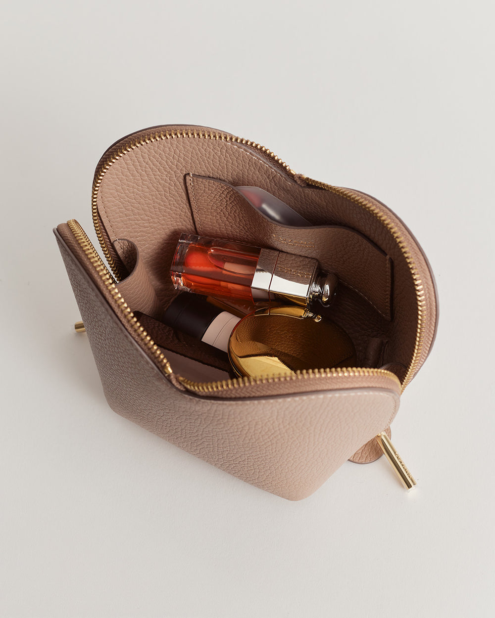Open cosmetic bag with various beauty products inside.