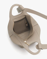 Open handbag showing interior with a small pocket and zipper.