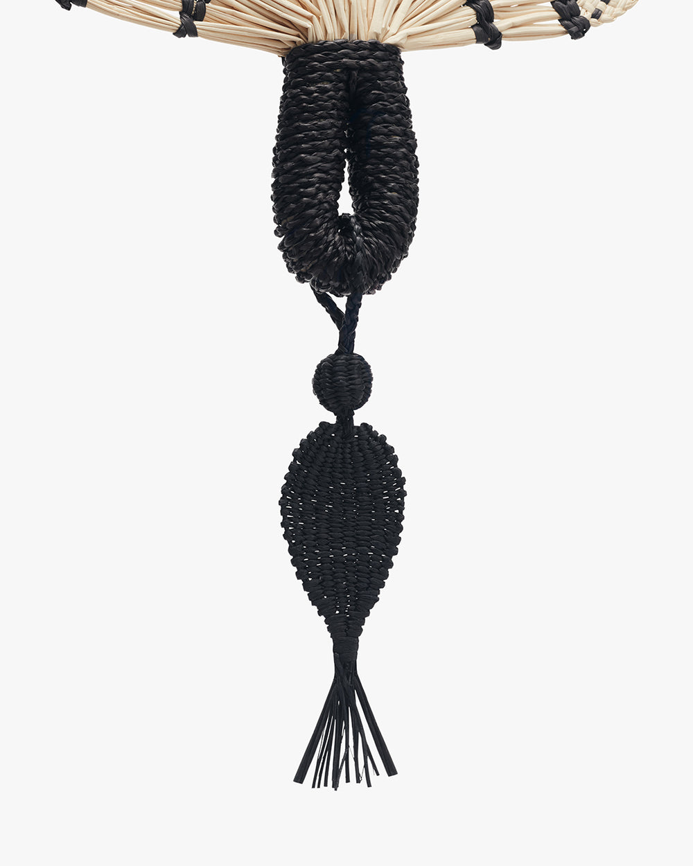 Woven decorative tassel hanging from a straw fan.