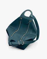 A geometric shoulder bag with a curved top handle, belt strap, and front zipper pocket