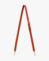 Adjustable strap with metal clasps and buckle on a plain background.