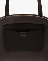 Close-up of a bag with a pocket featuring gold text detailing.