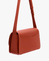 Rectangular leather shoulder bag with a large back pocket.