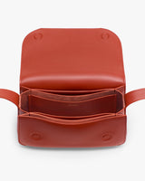 Open leather handbag showing interior compartments and stitching details.