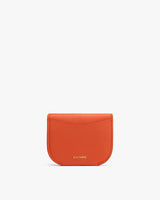 Small leather cardholder with a flap closure and brand text near the bottom.