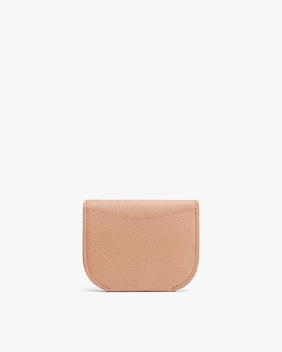 Small leather wallet with curved flap lying on flat surface