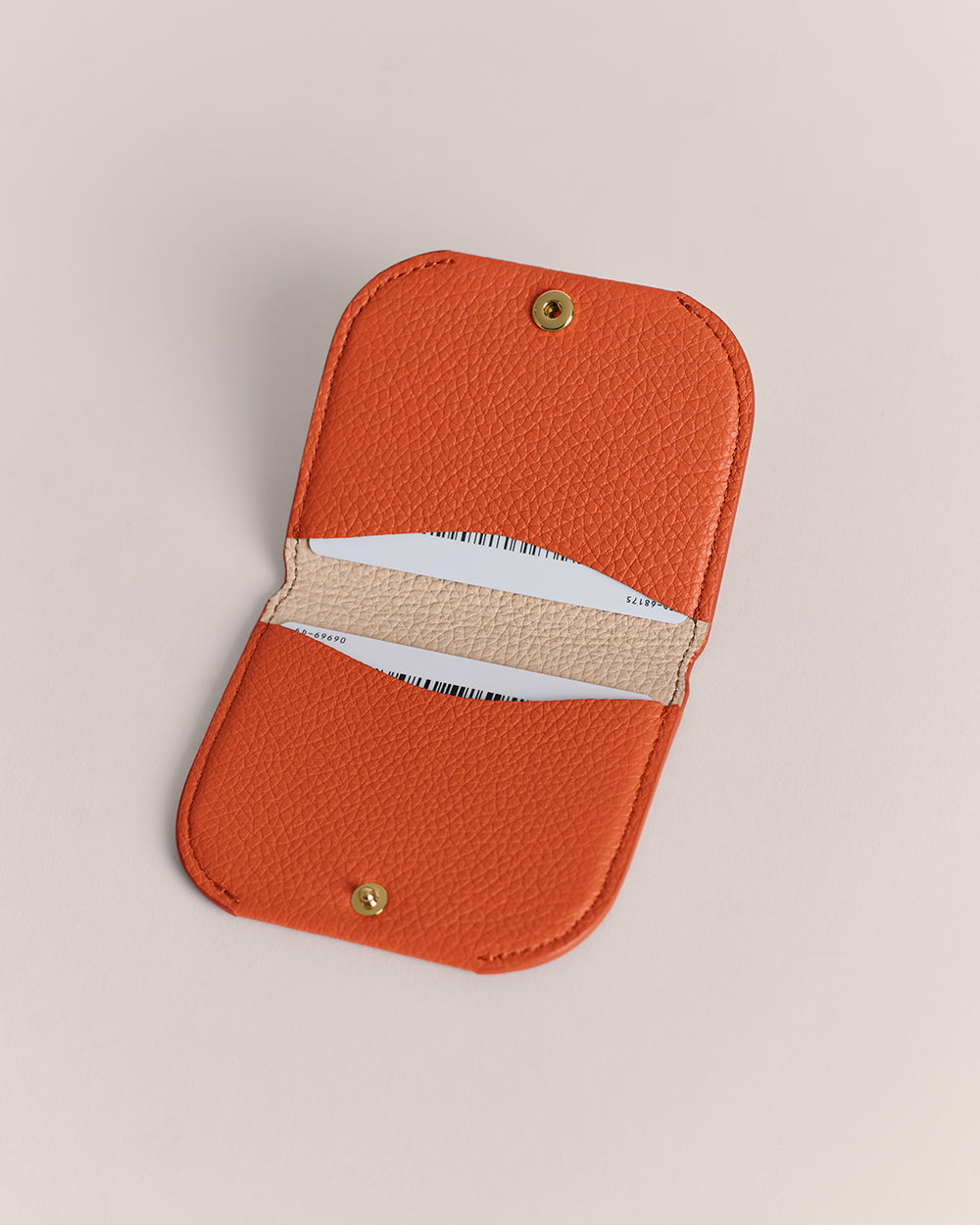 Small open cardholder with two compartments and a snap-button closure.