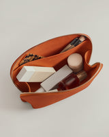 Open pouch with cosmetics and brushes inside