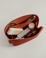 Open cosmetic pouch with makeup items inside