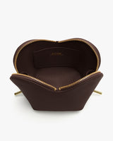 Open pouch with gold zipper and interior pocket.