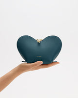 Hand holding heart-shaped pouch with zipper closure