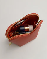 Open pouch with cosmetic items inside.
