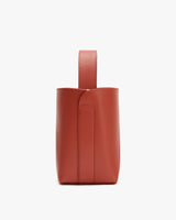 Handbag with a wide handle and open top viewed from the side.