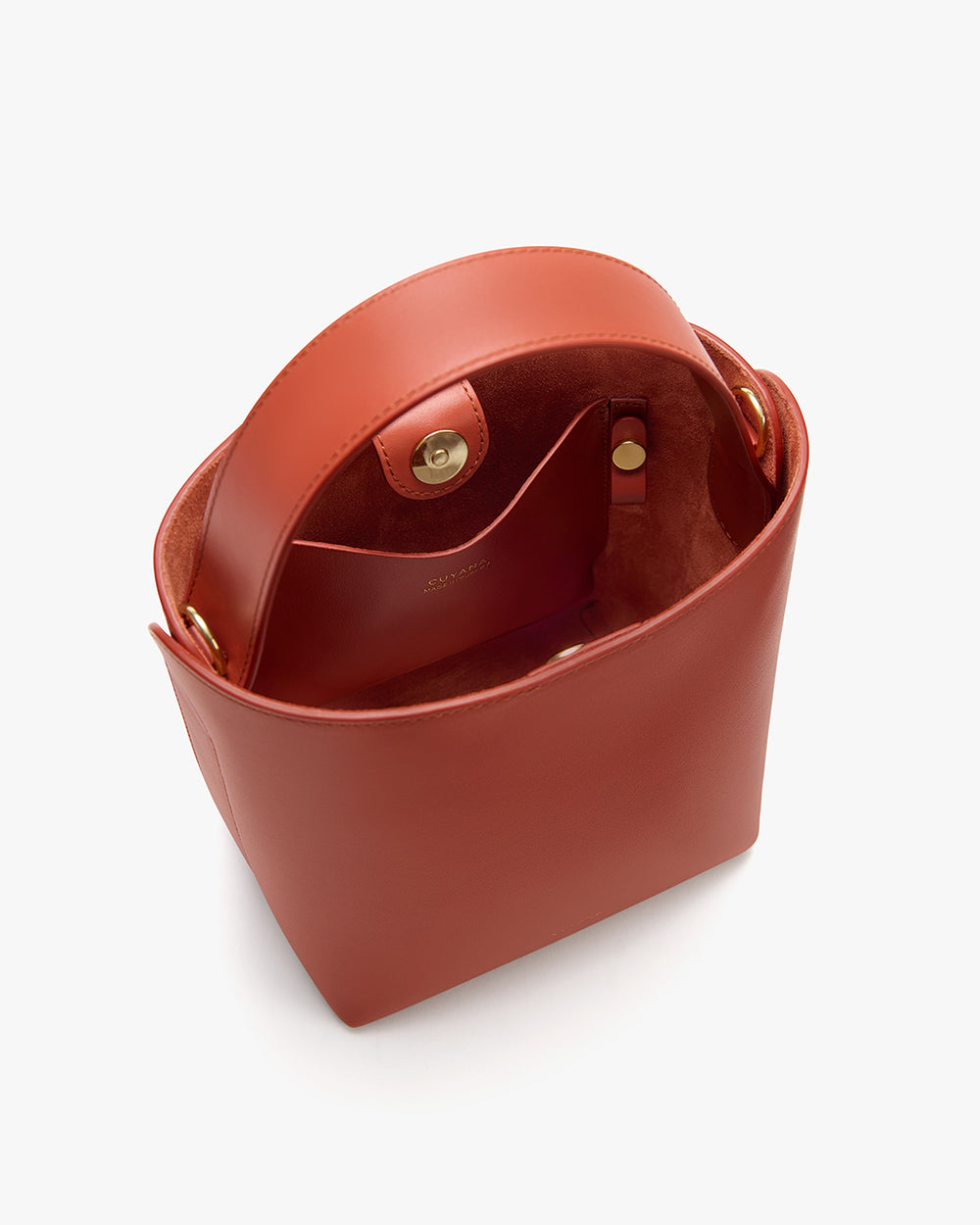 Open handbag with a clasp, showing interior compartments and metal fastenings.