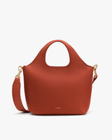 Handbag with round handles and shoulder strap