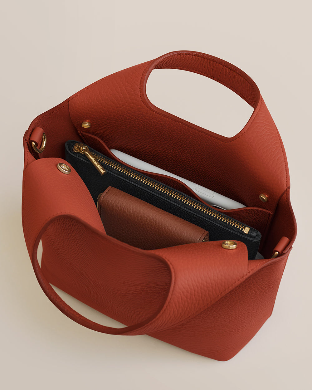 Open handbag with a zipper pouch and other contents inside.