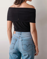 Person wearing off-shoulder top and jeans, facing away.