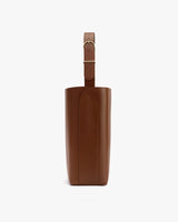 Side view of a structured handbag with a single shoulder strap.