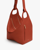 A handbag with two handles and zipper pockets.