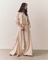 Person wearing a loose top with matching wide-leg pants standing indoors
