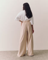Person in a white top and wide-leg pants, viewed from the back.