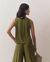 Person in sleeveless top and pants holding tote bag