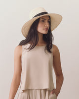 Person wearing a sleeveless top and a wide-brimmed hat.