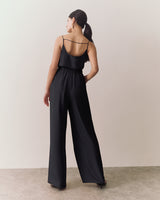 Woman walking in sleeveless top and wide-leg pants.