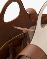 Open tote bag with cutout handles and interior pockets.