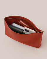 Open pouch with phone, notebook, wallet, and pen inside.
