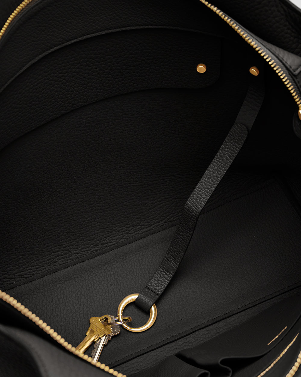 Open bag with a strap and keys inside.