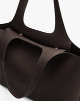 Close-up of a textured handbag with two handles.