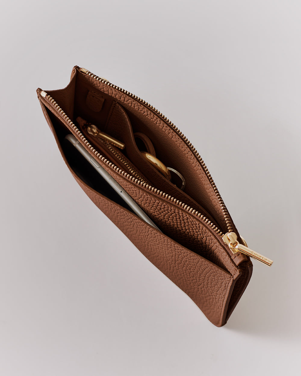 Top view of open textured pouch with zipper, showing contents inside.