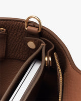 Bag interior with a zipped pocket, a laptop sleeve button, and a gold loop detail.