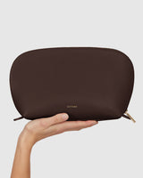 Hand holding a pouch with a zip closure.