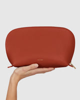 Hand holding a zippered leather pouch