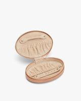 Oval-shaped jewelry box with zipper opened to reveal compartments inside.