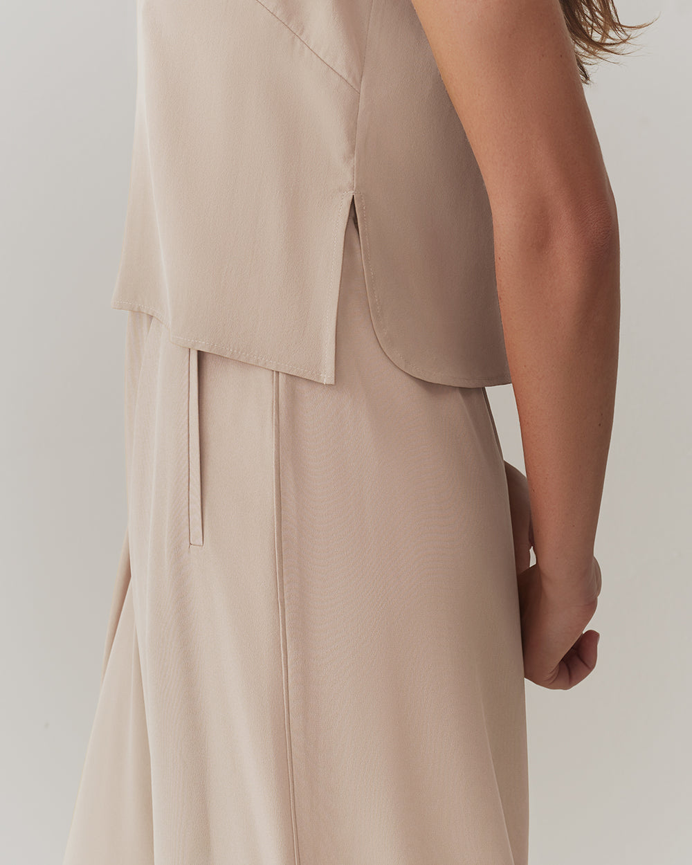 Person wearing sleeveless top viewed from the side.