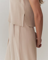 Person wearing sleeveless top viewed from the side.