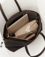 Open tote bag on chair showing pouches, wallet, keys inside