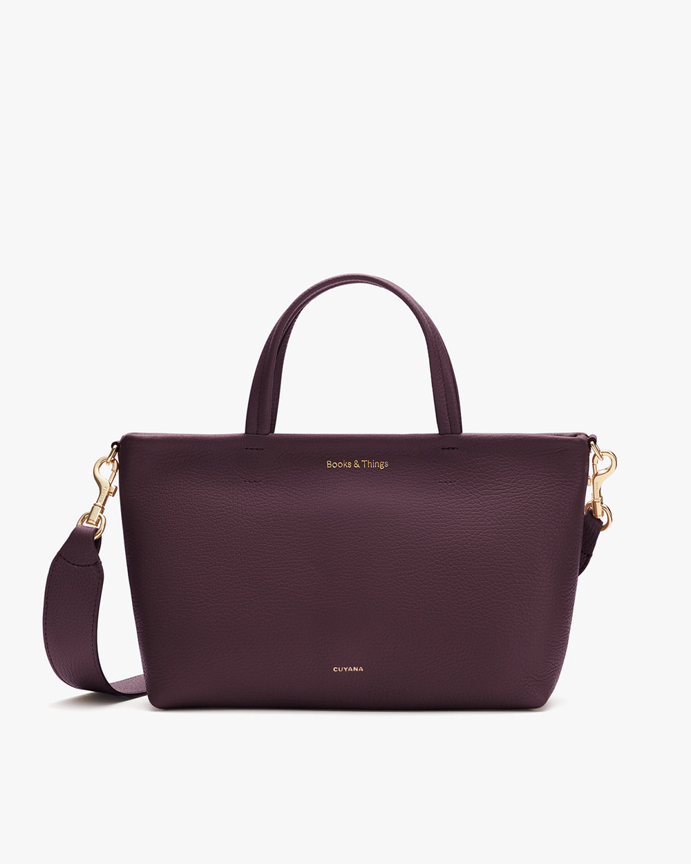 A handbag with a top handle, detachable shoulder strap, and small gold embossed text.
