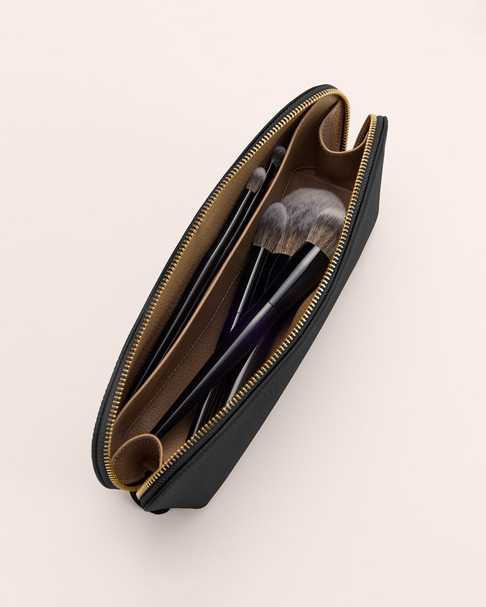 Makeup bag with brushes inside, top view.