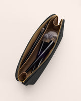 Makeup bag with brushes inside, top view.