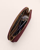 Open makeup bag with brushes inside shown from above.