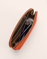 Open makeup pouch with brushes inside.