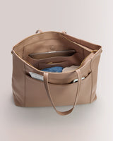 Open tote bag filled with folded clothing and documents.