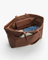 Open travel bag with a wallet, denim fabric, and white item inside