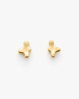 Abstract-shaped gold earrings on plain background.