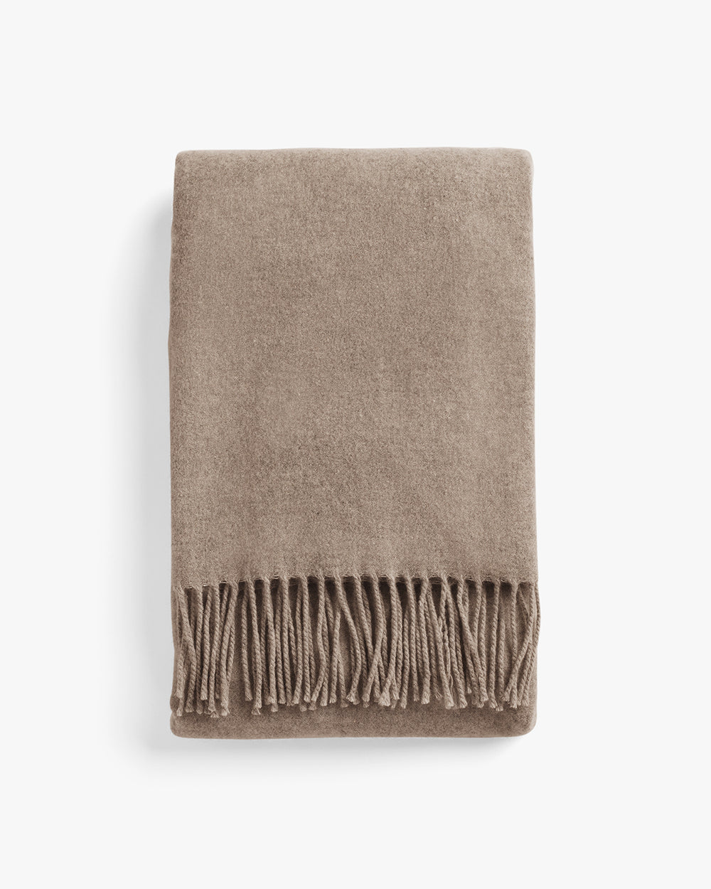 Folded blanket with fringed edges.